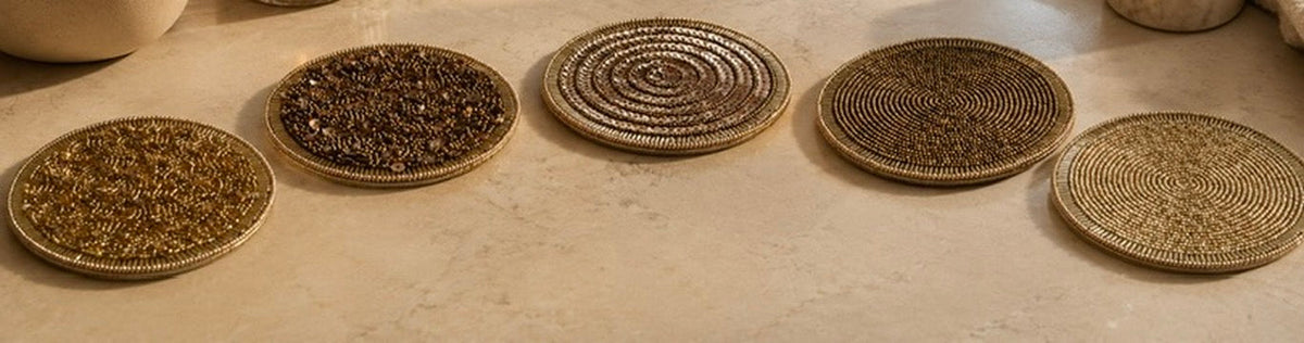 Beige interieur met luxe woonaccessoires en vijf handgemaakte kralen onderzetters op een lichte marmeren salontafel.