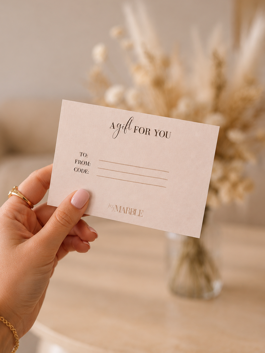 Vrouw houdt een luxe My Marble cadeaubon vast